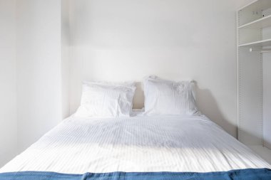 Düzenli, temiz, çarşaflı ve iki kabarık yastıklı bir yatak. Genel manzara, yatak odası, insan yok.