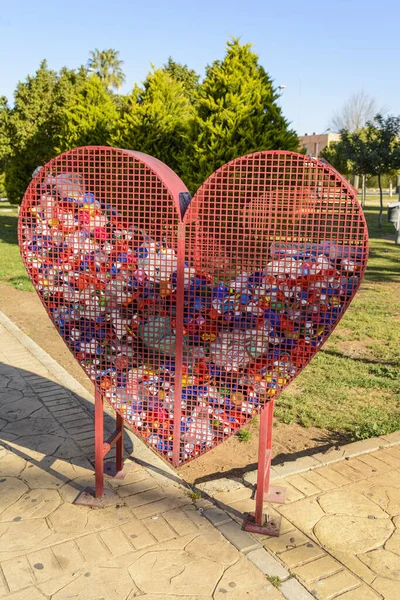 A heart-shaped container for recycling plastic bottle caps, symbolising our love for the planet. Recycling plastics helps to reduce pollution and keep our world clean and healthy.