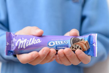 Arahal. Sevilla. İspanya. 18 Mart 2023. Milka Oreo markasından bir çikolata tutan bir çocuğun yakın çekimi. Aşırı şeker tüketimi çocuk sağlığı üzerinde olumsuz sonuçlar doğurabilir.