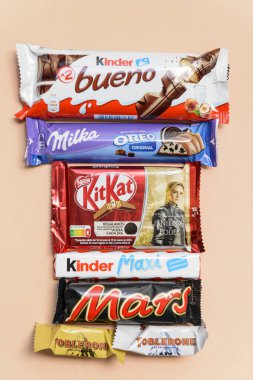 Arahal. Seville. Spain. March 18, 2023. Still life with chocolates bars of different brands on light orange background . Excessive consumption of sugar can have negative consequences on health. clipart