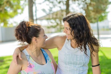 Spor kıyafetleriyle parkta spor yapan iki orta yaşlı kadın. Arkadaşlık, spor ve sağlıklı yaşam tarzı kavramları.