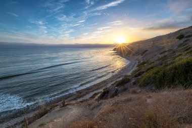 Sakin günbatımının engebeli uçurumları ve okyanus yollarının görkemli kıyı manzarasını aydınlattığı Catalina Patikası boyunca huzurlu bir yolculuğa çıkın, Rancho Palos Verdes, Kaliforniya.