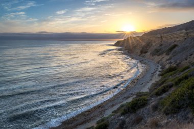 Sakin günbatımının engebeli uçurumları ve okyanus yollarının görkemli kıyı manzarasını aydınlattığı Catalina Patikası boyunca huzurlu bir yolculuğa çıkın, Rancho Palos Verdes, Kaliforniya.