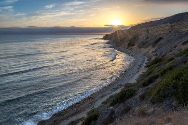 Sakin günbatımının engebeli uçurumları ve okyanus yollarının görkemli kıyı manzarasını aydınlattığı Catalina Patikası boyunca huzurlu bir yolculuğa çıkın, Rancho Palos Verdes, Kaliforniya.