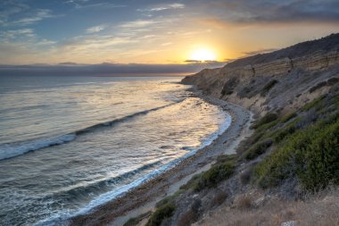 Sakin günbatımının engebeli uçurumları ve okyanus yollarının görkemli kıyı manzarasını aydınlattığı Catalina Patikası boyunca huzurlu bir yolculuğa çıkın, Rancho Palos Verdes, Kaliforniya.