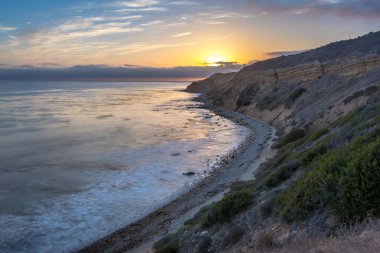 Sakin günbatımının engebeli uçurumları ve okyanus yollarının görkemli kıyı manzarasını aydınlattığı Catalina Patikası boyunca huzurlu bir yolculuğa çıkın, Rancho Palos Verdes, Kaliforniya.