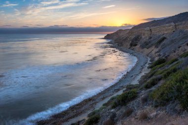 Sakin günbatımının engebeli uçurumları ve okyanus yollarının görkemli kıyı manzarasını aydınlattığı Catalina Patikası boyunca huzurlu bir yolculuğa çıkın, Rancho Palos Verdes, Kaliforniya.