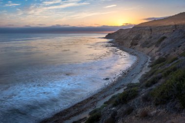 Sakin günbatımının engebeli uçurumları ve okyanus yollarının görkemli kıyı manzarasını aydınlattığı Catalina Patikası boyunca huzurlu bir yolculuğa çıkın, Rancho Palos Verdes, Kaliforniya.