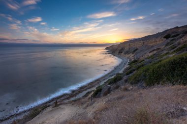 Sakin günbatımının engebeli uçurumları ve okyanus yollarının görkemli kıyı manzarasını aydınlattığı Catalina Patikası boyunca huzurlu bir yolculuğa çıkın, Rancho Palos Verdes, Kaliforniya.
