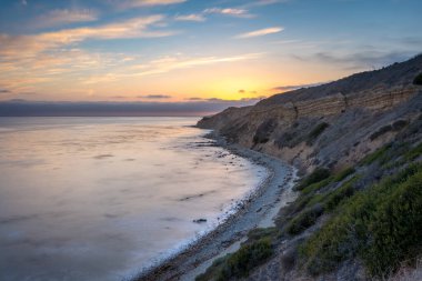 Sakin günbatımının engebeli uçurumları ve okyanus yollarının görkemli kıyı manzarasını aydınlattığı Catalina Patikası boyunca huzurlu bir yolculuğa çıkın, Rancho Palos Verdes, Kaliforniya.