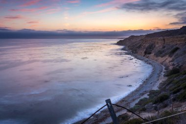 Sakin günbatımının engebeli uçurumları ve okyanus yollarının görkemli kıyı manzarasını aydınlattığı Catalina Patikası boyunca huzurlu bir yolculuğa çıkın, Rancho Palos Verdes, Kaliforniya.