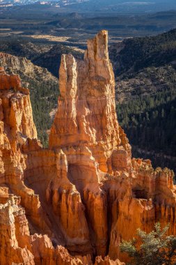 Towering hoodoos rise dramatically against a scenic backdrop in Bryce Canyon, offering a stunning view of sandstone formations and vast landscape. clipart