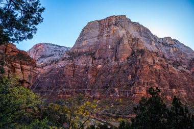 Kum tepeleri, Utah 'ta gün batımının ılık ışığını yakalıyor. Yürüyüşçüleri, Zion Ulusal Parkı' nın manzaralı manzaralarını keşfetmeye davet ediyor..