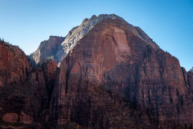 Kum tepeleri, Utah 'ta gün batımının ılık ışığını yakalıyor. Yürüyüşçüleri, Zion Ulusal Parkı' nın manzaralı manzaralarını keşfetmeye davet ediyor..
