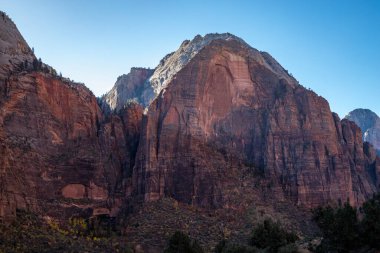 Kum tepeleri, Utah 'ta gün batımının ılık ışığını yakalıyor. Yürüyüşçüleri, Zion Ulusal Parkı' nın manzaralı manzaralarını keşfetmeye davet ediyor..