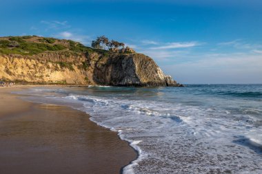 Crystal Cove Sahili 'nde yumuşak dalgalar ve Laguna Sahili, Kaliforniya' da manzaralı bir uçurum var. Ziyaretçileri kıyı güzelliğinin tadını çıkarmaya davet ediyor..