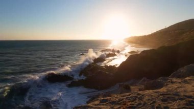 Malibu, Kaliforniya 'daki Leo Carrillo Eyalet Plajı kayalık bir kıyı şeridi, yumuşak dalgalar ve sakin sahil güzelliği ile sakin bir günbatımı sergiliyor.