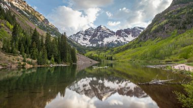 Maroon Gölü 'nün heybetli Maroon Çanları' nı yakaladığı sakin bir manzara sakin suya yansıdı. Bereketli yeşillik sakin sahneyi çevreledi.