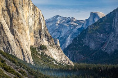 Visitors enjoy a hiking adventure in Yosemite Valley, surrounded by majestic mountains and iconic rock formations like Half Dome and El Capitan. clipart