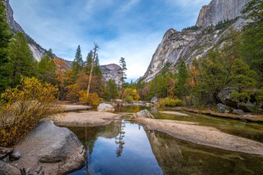 Yosemite Ulusal Parkı 'ndaki görkemli Sierra Nevada Dağları' nı yansıtan Ayna Gölü 'nün sakin sularını renkli sonbahar yaprakları kaplar..