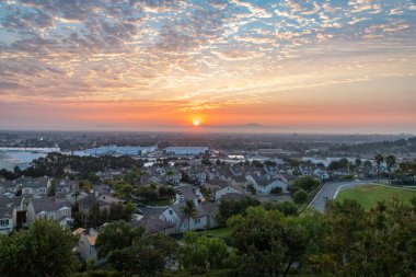 Canlı gün doğumu, Signal Hill 'in üzerine sıcak bir ışık saçıyor. Sakin şehir siluetini aydınlatıyor. Huzur ve rahatlama anlarını davet ediyor..
