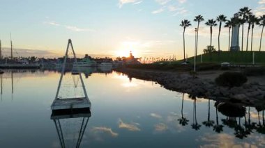 Gökkuşağı Limanı, Long Beach, California 'nın güneşli havadan çekimleri sakin sularla birlikte renkli gökyüzünü yansıtıyor.