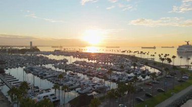 Gökkuşağı Limanı, Long Beach, California 'nın güneşli havadan çekimleri sakin sularla birlikte renkli gökyüzünü yansıtıyor.