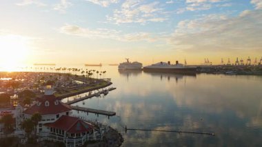 Gökkuşağı Limanı, Long Beach, California 'nın güneşli havadan çekimleri sakin sularla birlikte renkli gökyüzünü yansıtıyor.
