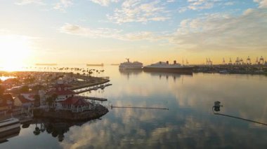 Gökkuşağı Limanı, Long Beach, California 'nın güneşli havadan çekimleri sakin sularla birlikte renkli gökyüzünü yansıtıyor.