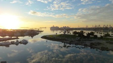 Gökkuşağı Limanı, Long Beach, California 'nın güneşli havadan çekimleri sakin sularla birlikte renkli gökyüzünü yansıtıyor.