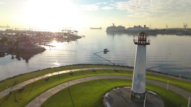 Gökkuşağı Limanı ve Lions Lighthouse, Long Beach, Kaliforniya 'nın şafak vakti renkli gökyüzünü yansıtan sakin sularının hava görüntüsü.