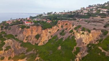 Bluff Cove, Palos Verdes Estates, Kaliforniya 'nın bulutlu bir günde kayalık plaja doğru uçan vinç görüntüsü.