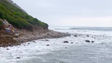 Bluff Cove, Palos Verdes Gayrimenkul 'ün hava üssü dramatik uçurumlar ve dalgaların telefoto lensleriyle kayalık sahile çarptığı bulutlu bir günde Kaliforniya' da.