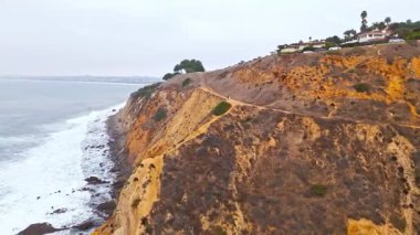 Kaliforniya, Palos Verdes Konutları 'nda bulutlu bir günde Düz Nokta Kayası' na çarpan dalgaların yukarıdan aşağı havadan çekilmiş görüntüsü