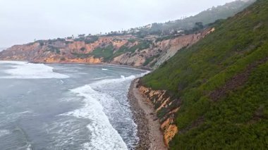 Düz Nokta Sahili ve Düz Nokta Kayası 'nın havadan çekimi, Palos Verdes Evleri, Kaliforniya, bulutlu bir günde dalgalar engebeli kıyı şeridine çarpıyor.