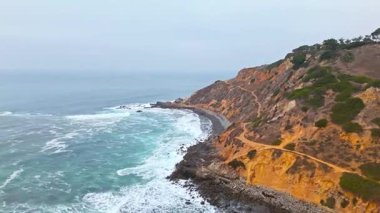 Düz Nokta Sahili ve Düz Nokta Kayası 'nın havadan çekimi, Palos Verdes Evleri, Kaliforniya, bulutlu bir günde dalgalar engebeli kıyı şeridine çarpıyor.