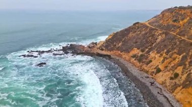Bluff Cove, Palos Verdes Estates, Kaliforniya 'nın geniş hava görüntüleri dramatik uçurumlar ve dalgaların kayalık sahile çarptığı bulutlu bir günde