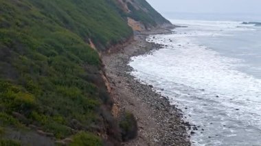 Bluff Cove, Palos Verdes Gayrimenkul 'ün hava üssü dramatik uçurumlar ve dalgaların telefoto lensleriyle kayalık sahile çarptığı bulutlu bir günde Kaliforniya' da.