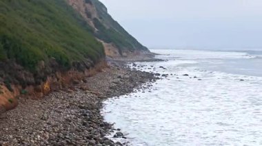 Düz Nokta Sahili ve Düz Nokta Kayası 'nın alçak hava görüntüsü, Palos Verdes Konutları, Kaliforniya, engebeli kıyı şeridine dalgaların çarptığı bulutlu bir günde