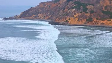 Düz Noktalı Kaya ve Düz Noktalı Kaya 'nın hava telefoto görüntüsü, Palos Verdes Estates, Kaliforniya' da engebeli kıyı şeridine dalgaların çarptığı bulutlu bir günde