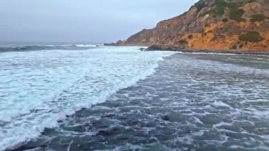 Düz Nokta Sahili ve Düz Nokta Kayası 'nın alçak hava görüntüsü, Palos Verdes Konutları, Kaliforniya, engebeli kıyı şeridine dalgaların çarptığı bulutlu bir günde