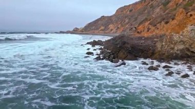 Düz Nokta Sahili ve Düz Nokta Kayası 'nın alçak hava görüntüsü, Palos Verdes Konutları, Kaliforniya, engebeli kıyı şeridine dalgaların çarptığı bulutlu bir günde