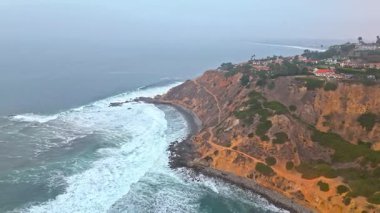 Düz Nokta Sahili ve Düz Nokta Kayası 'nın havadan çekimi, Palos Verdes Evleri, Kaliforniya, bulutlu bir günde dalgalar engebeli kıyı şeridine çarpıyor.