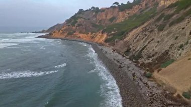 Bluff Cove, Palos Verdes Estates, Kaliforniya 'nın hava görüntüleri dramatik uçurumlar ve dalgaların kayalık sahile çarptığı bulutlu bir günde
