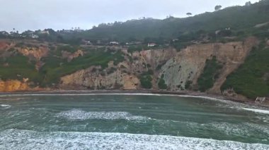 Palos Verdes Evleri, Kaliforniya 'da bulutlu bir günde Bluff Cove' un kayalık kıyılarına çarpan dalgaların yukarıdan aşağıya doğru görüntüsü.