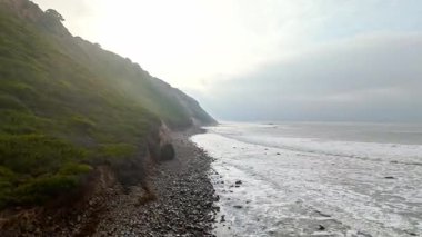 Bluff Cove, Palos Verdes Gayrimenkul, Kaliforniya 'da sisli bir günde dramatik uçurumlar ve dalgalar kayalık sahile çarpıyor.