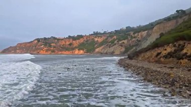 Düz Nokta Sahili ve Düz Nokta Kayası 'nın havadan çekimi, Palos Verdes Evleri, Kaliforniya, bulutlu bir günde dalgalar engebeli kıyı şeridine çarpıyor.