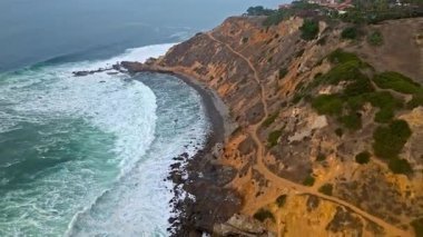 Bluff Cove, Palos Verdes Gayrimenkul, Kaliforniya 'da sisli bir günde dramatik uçurumlar ve dalgalar kayalık sahile çarpıyor.