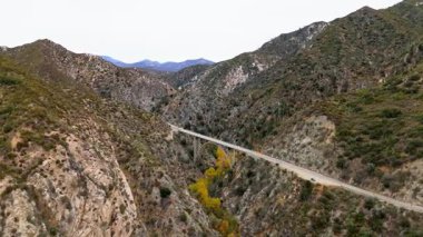 Büyük Tujunga Narrows Köprüsü 'nün Angeles Orman Otoyolu, Angeles Ulusal Ormanı, Kaliforniya' daki hava yörüngesinde canlı sonbahar yaprakları ve görkemli dağ manzaraları sergilenmektedir..
