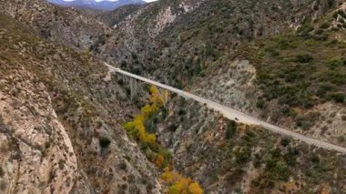 Angeles Orman Yolu boyunca uzanan Büyük Tujunga Narrows Köprüsü Havalimanı, Angeles Ulusal Ormanı, Kaliforniya, canlı sonbahar yeşillikleri ve görkemli dağ manzaraları sergilenmektedir..